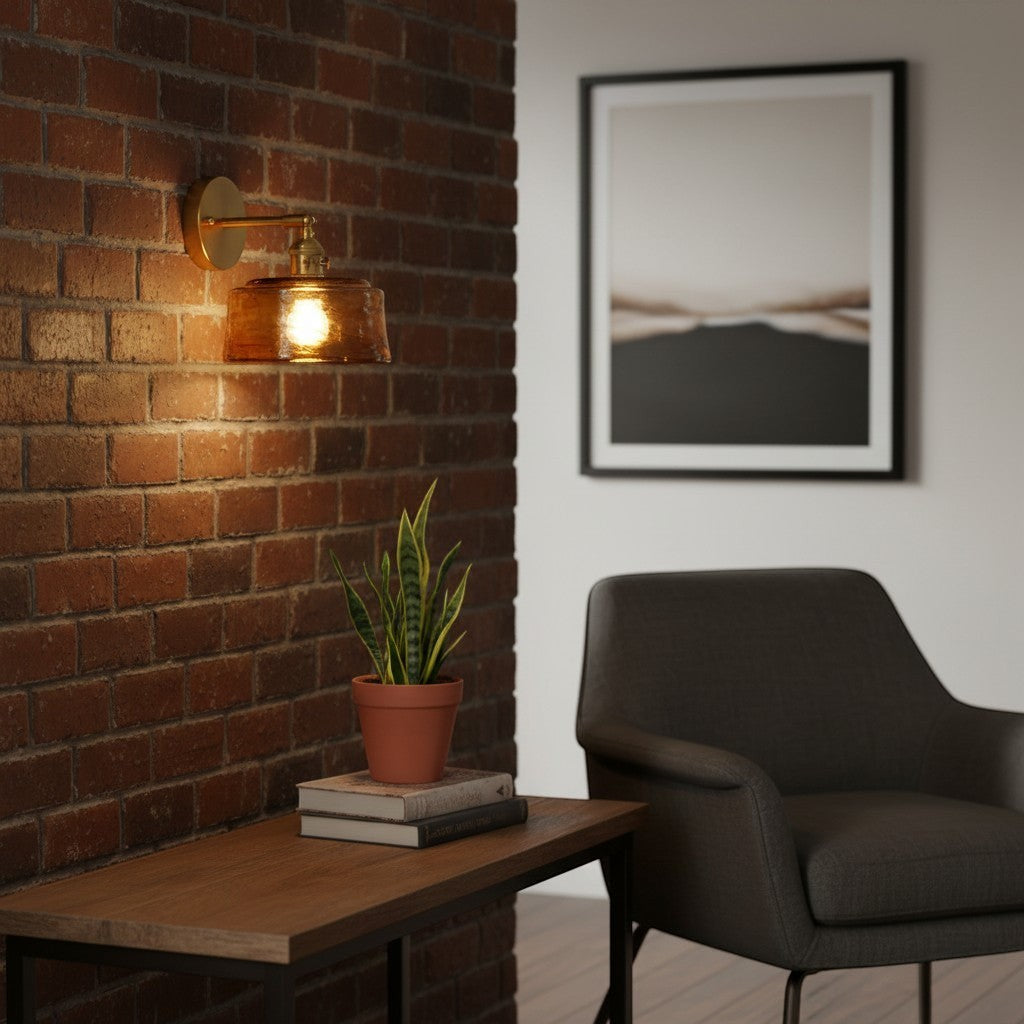 Applique murale goodlampe en laiton avec abat-jour en verre ambré texturé installée sur un mur en briques rouges