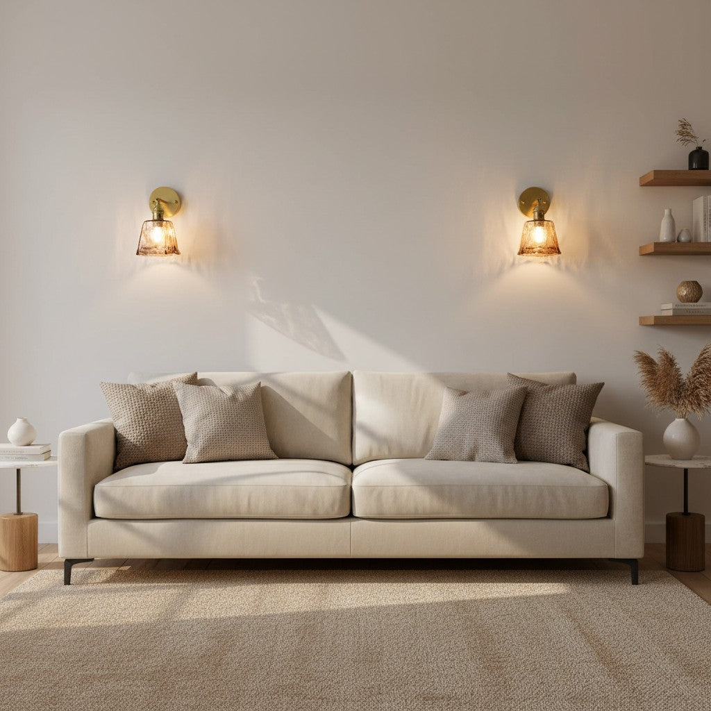 Applique murale goodlampe en verre ambré et laiton au-dessus d'un canapé beige dans un salon au style nordique