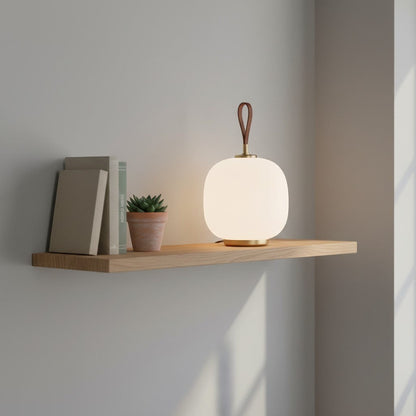 Lampe de table goodlampe en verre blanc opale avec anse en cuir et base dorée, design danois moderne.