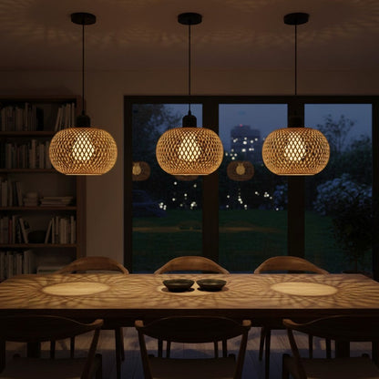 Trois suspensions goodlampe en bambou tressé à la main diffusant une lumière chaleureuse au-dessus d'une table à manger